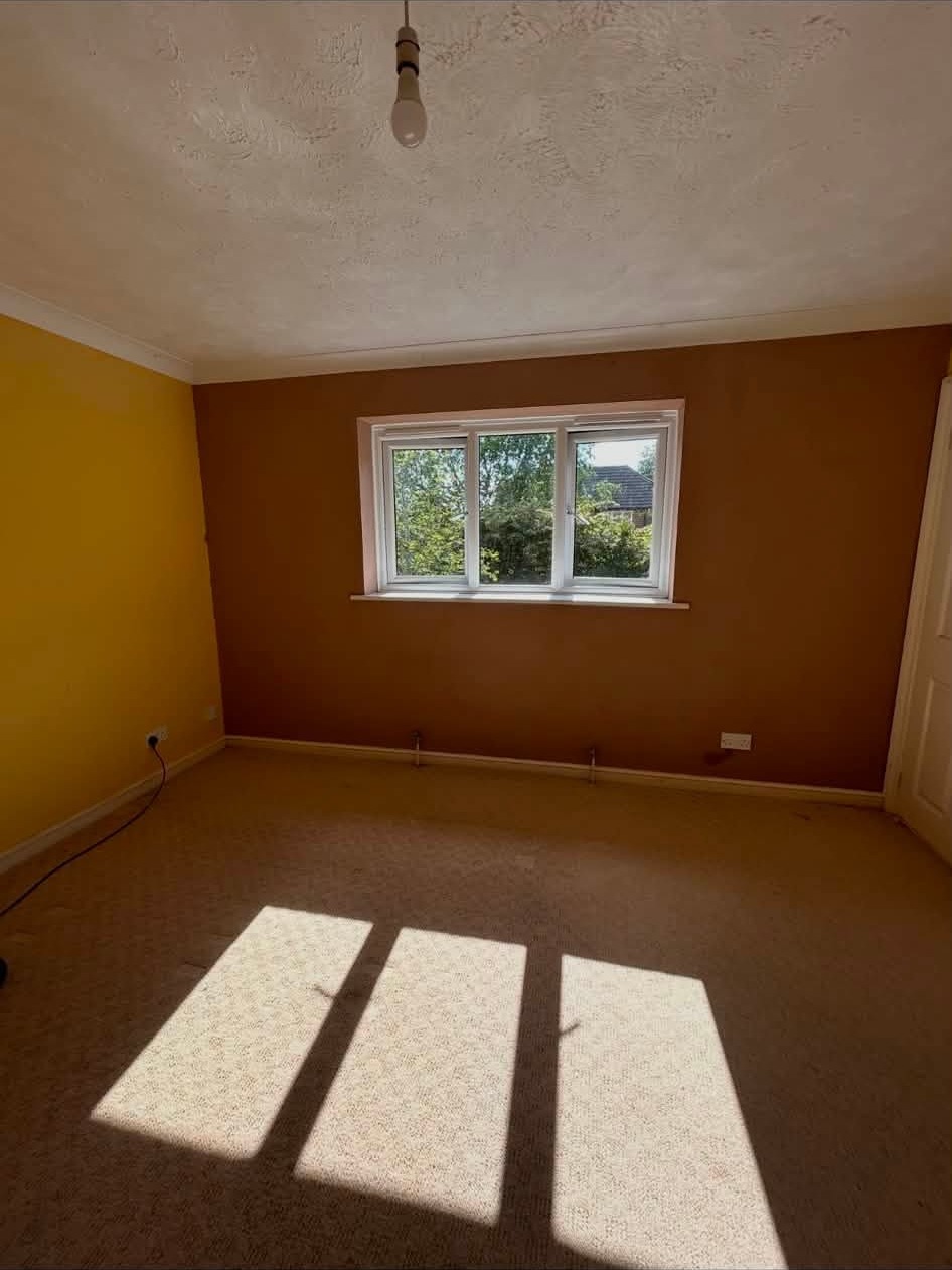 Bedroom with orange painted walls before the old plaster came off