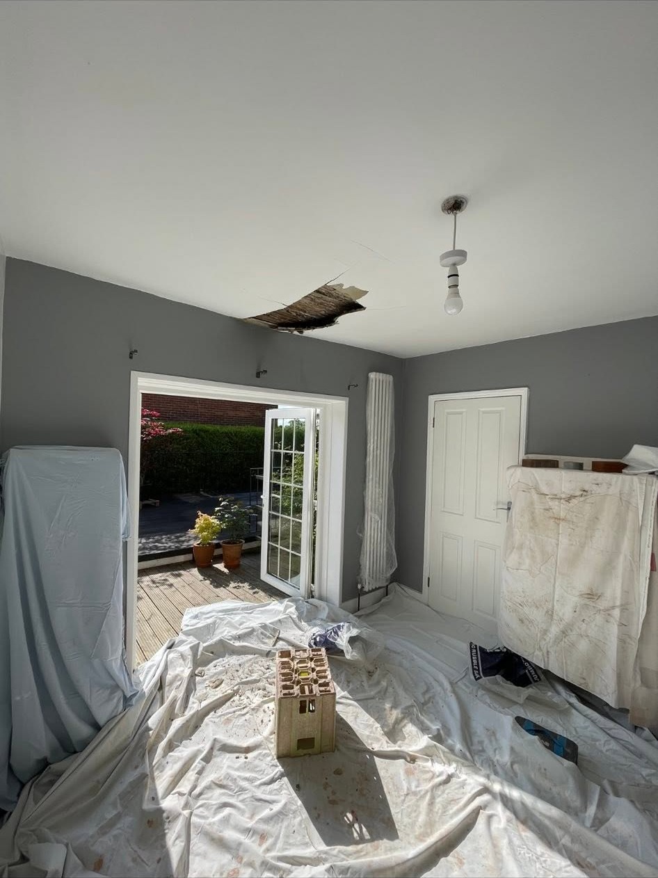 Ceiling opened up for repair, room protected with dust sheets