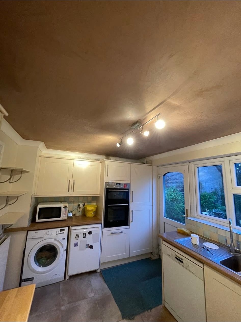 Kitchen with a freshly plastered ceiling and track lighting