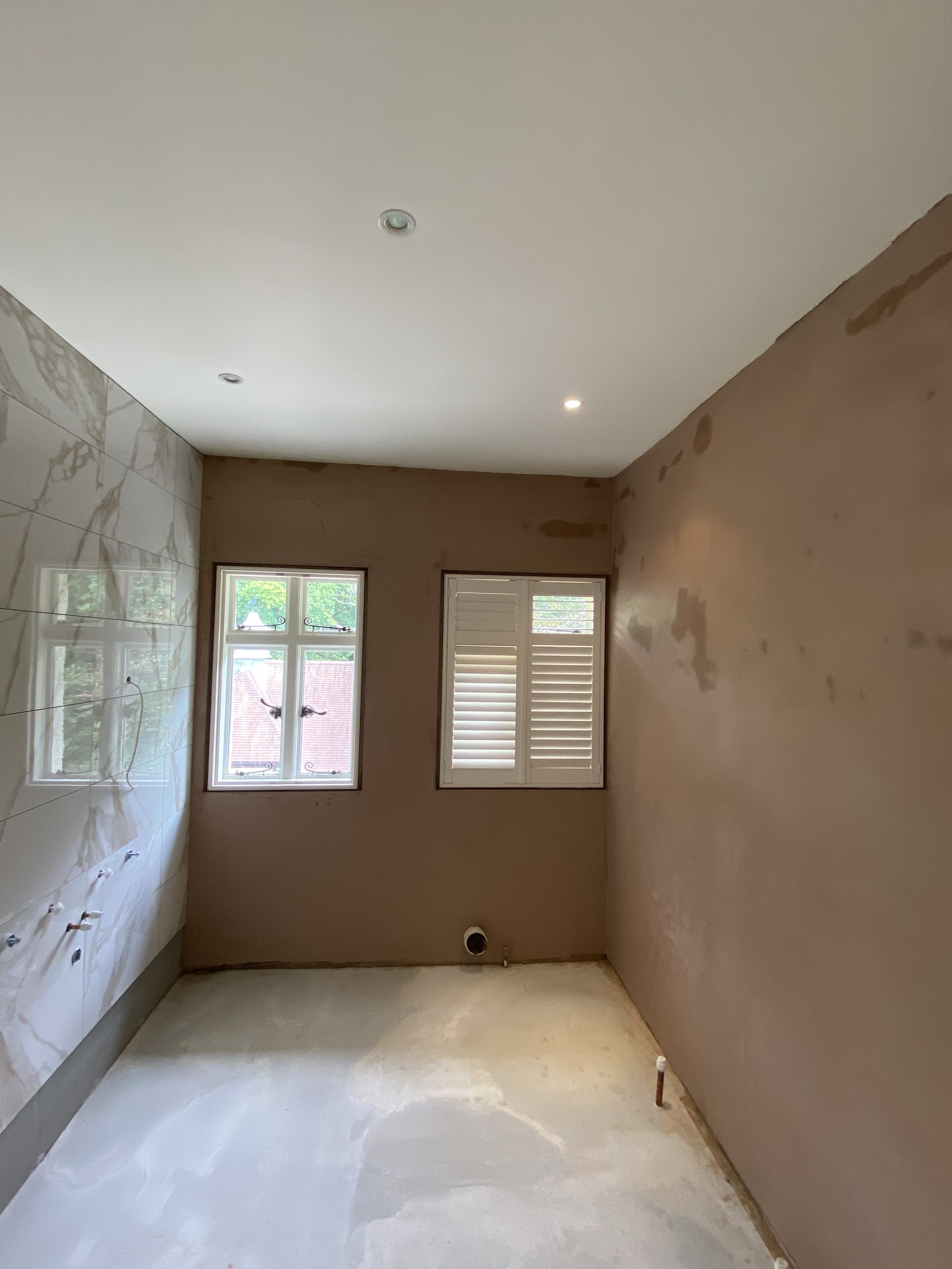 Room with fresh plaster on the walls and shutters at the window